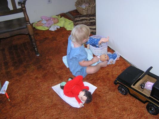 Sarah is a good little Mama. She puts the baby in the basket.