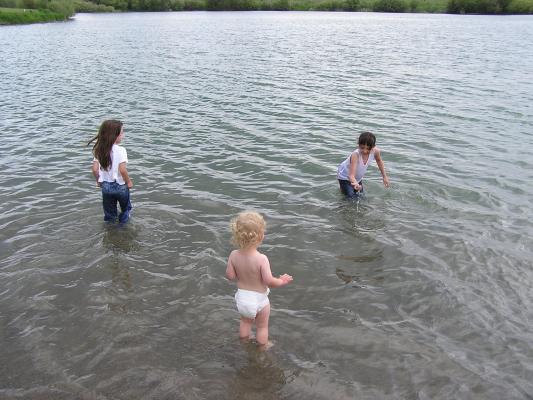 Malia, Andrea, and Noah play in the lake.