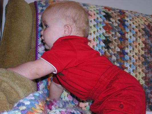 Noah climbs on the couch.