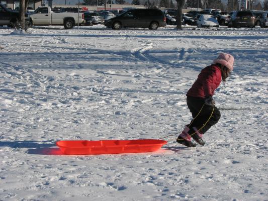 Andrea pulls the sled back up the hill.