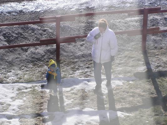 Noah and Katie play out side, but the snow is mostly melted.