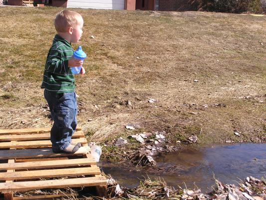 Noah found a cool bridge. He is coughing.
