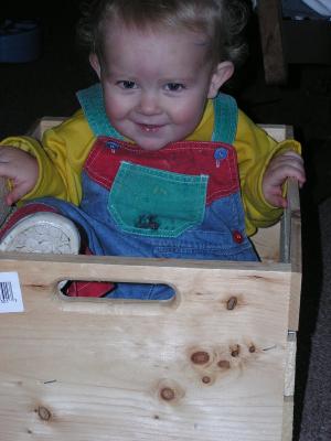 Noah smiles from his wooden box.