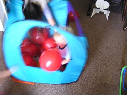 Noah plays with balloons in his tent.