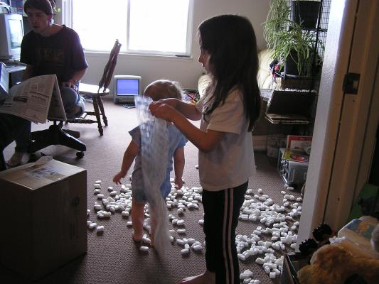 Andrea and Noah play with peanuts and bubble wrap.
