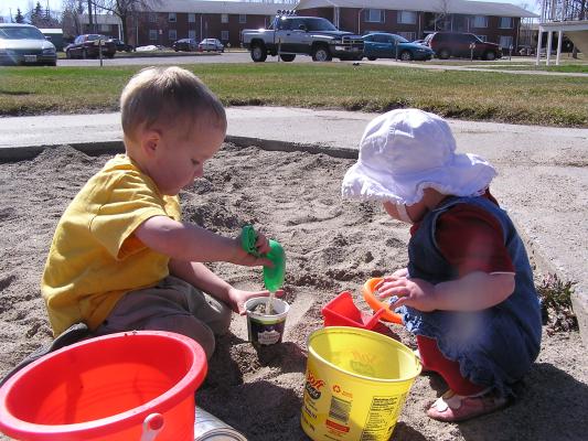 Noah and Sarah play in the sand.