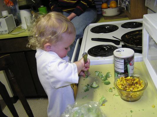 Noah chops up some brocolli.