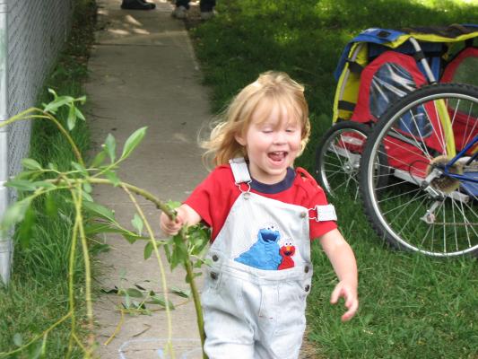 Sarah in overalls with tree branch.