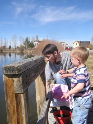 Noah throws rocks off the fishing dock.