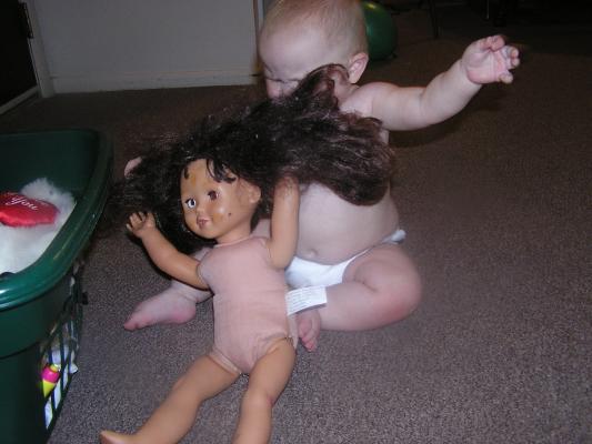 Sarah picks out the doll from the toy basket.