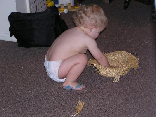 Noah plays with an old straw hat.