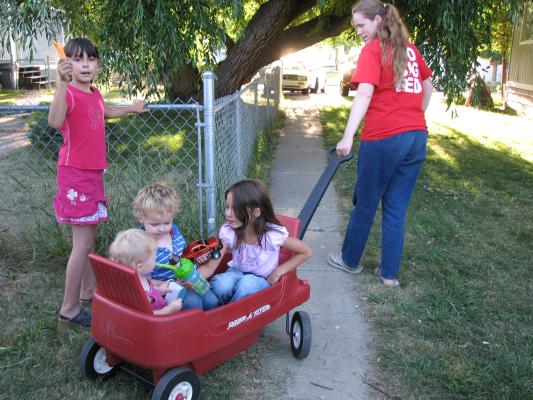 Katie's wagon is full. It holds, Sarah, Noah and Andrea. Malia is walking along.