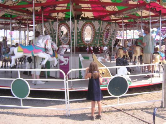 Andrea watches Katie and Sarah ride the merry-go-round
