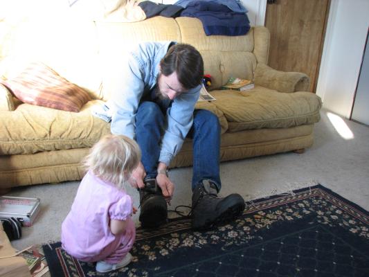 Sarah help daddy tie his shoes.