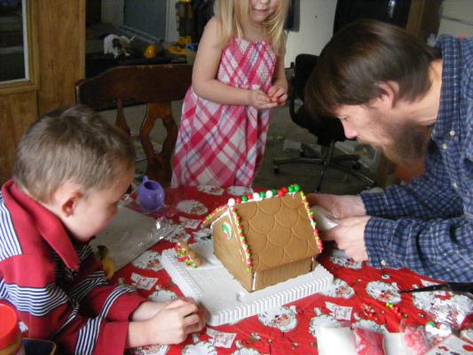 Noah, Sarah and David make a gingerbread house.