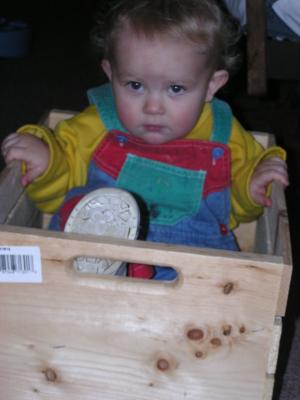 Noah plays in his new wooden box.