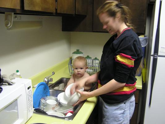 Noah helps mommy wash the dishes.