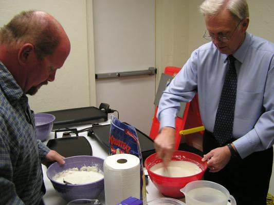 Mike and Bill stir the pancake batter for Easter breakfast.