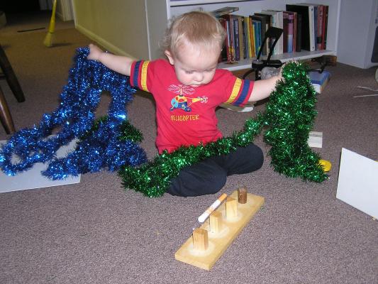 Noah plays with green and blue tinsel.