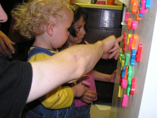Noah plays with the letters on the fridge.