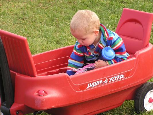 Noah organizes the toys in the wagon.