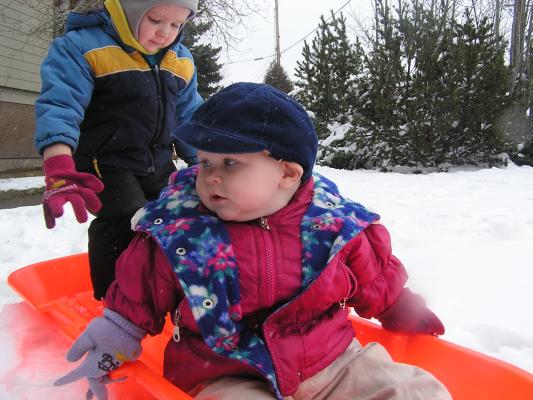 Sarah and Noah play in the orange sled.
