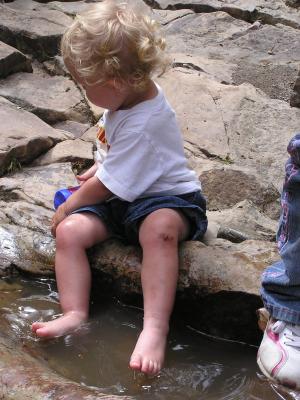 Andrea and Noah play in the little puddles.