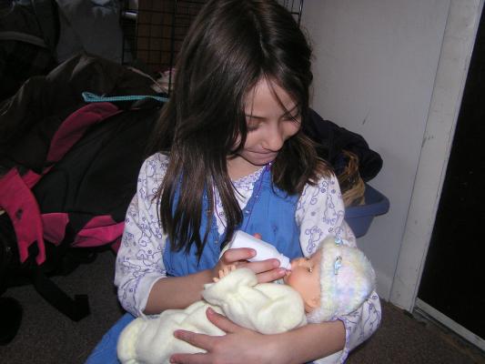 Andrea feeds Sarah's new baby.