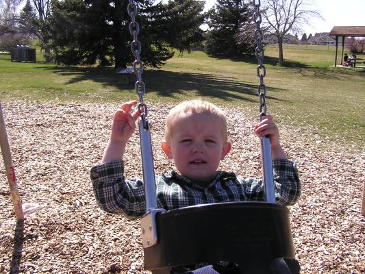 Noah swings at the park.