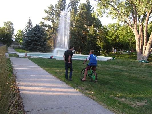 David and Joe talk while Sarah and Noah play in the Fountain