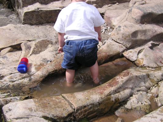 Noah stands in the water.