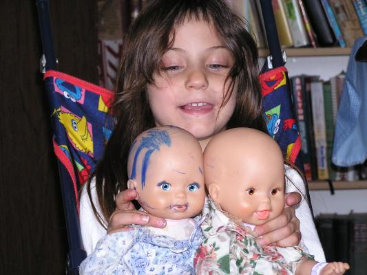 Andrea show off two dolls.
