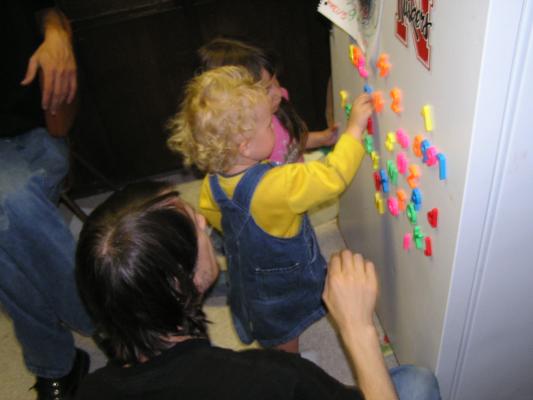 Noah plays with the letters on the fridge.