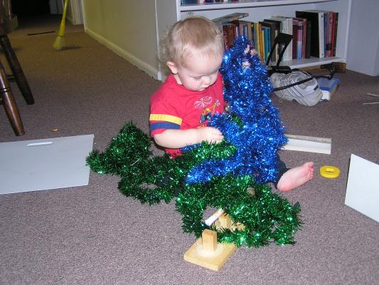 Noah plays with green and blue tinsel.