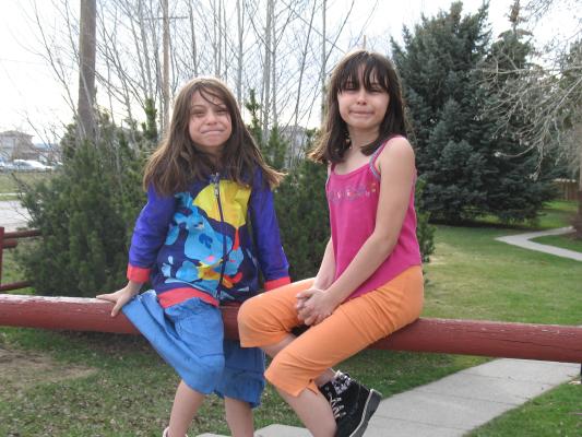 Andrea and Malia sit on the fence for a portrait.