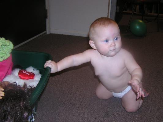 Sarah uses the toy basket to help yer get up.