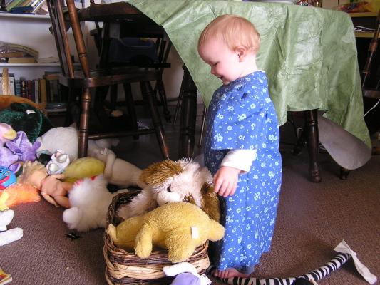 Sarah is bery happy to  play with stuffed toys in a basket.