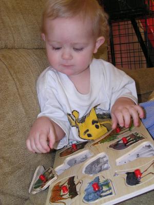 Noah plays with his animal puzzle.