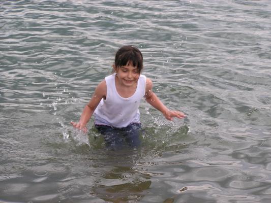 Malia splashes in the water.