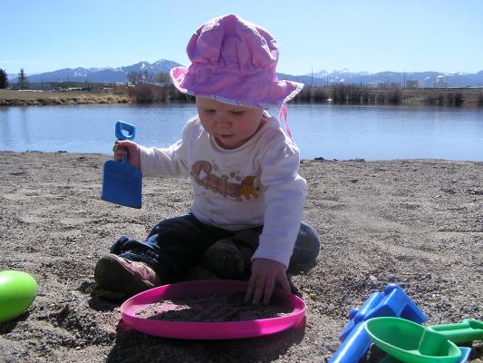 Sarah puts sand in a frisbee.