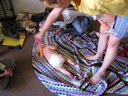 Katie tries to use a carrot to help Sarah roll over.