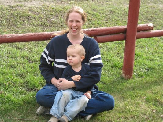 Katie and Noah sit by the fence for a portrait.
