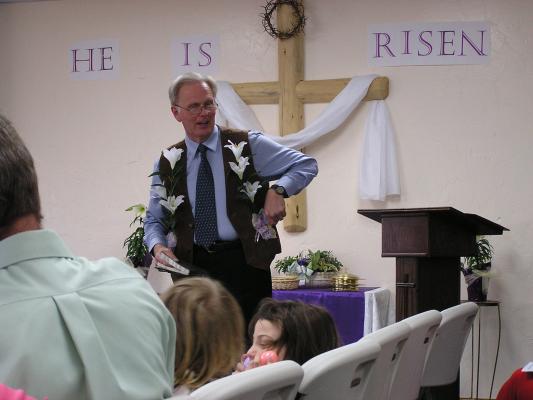 Bill preaches with the Easter decorations still attached.