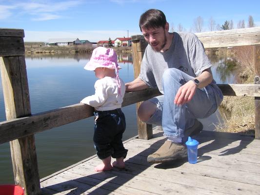 Sarah throws rocks off the dock.
