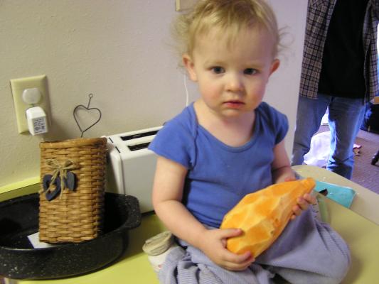 Noah plays with the big sweet potato.