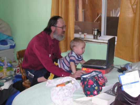 Noah watches Grandpa play on the computer.