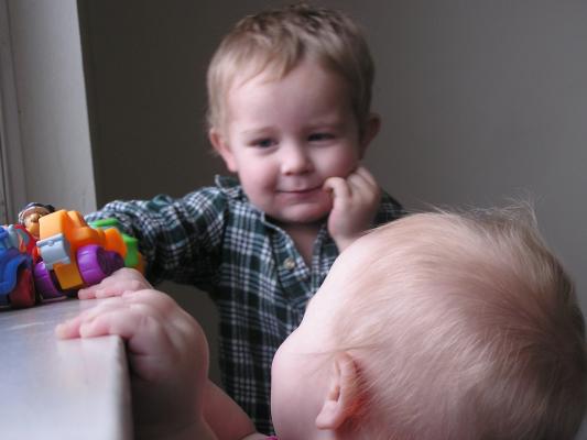 Noah and Sarah play cars at the window.
