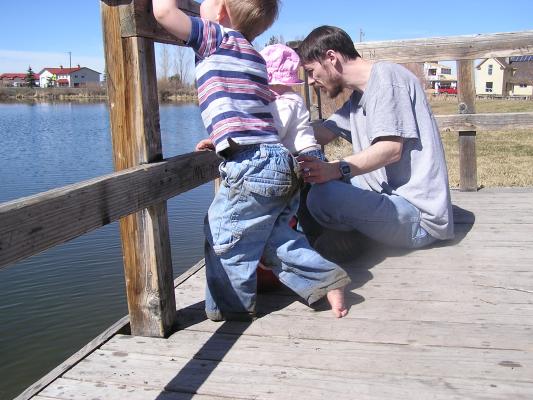 Noah and Sarah throw rocks off the dock.