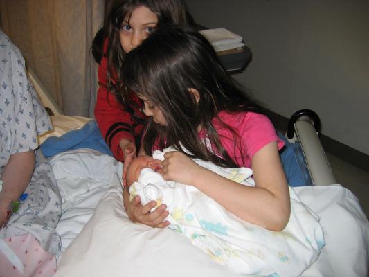 Malia holds Sarah on the hospital bed.