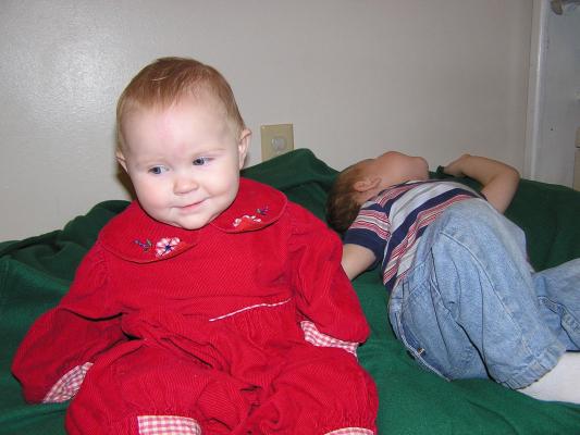 Sarah and Noah on his bed with a gree blanket.